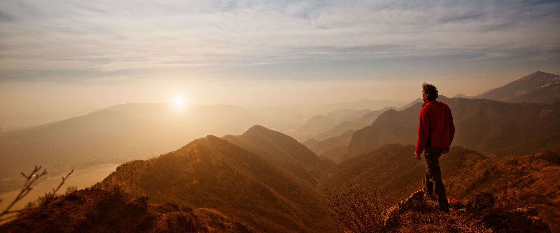 Man stands on mountain looking at sunrise