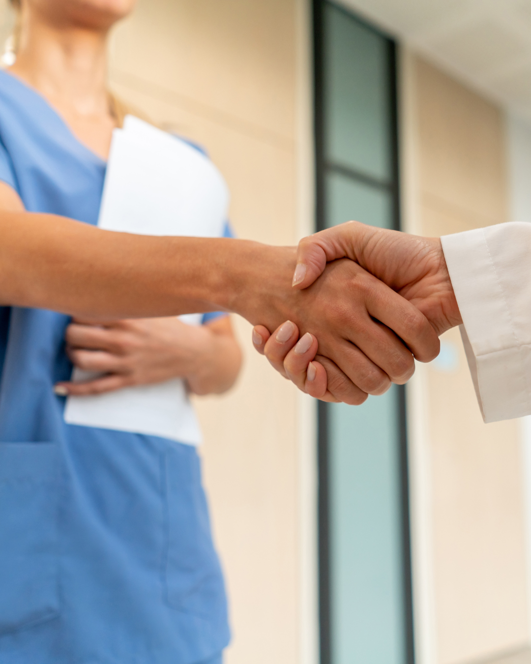 Two clinical staff members shake hands